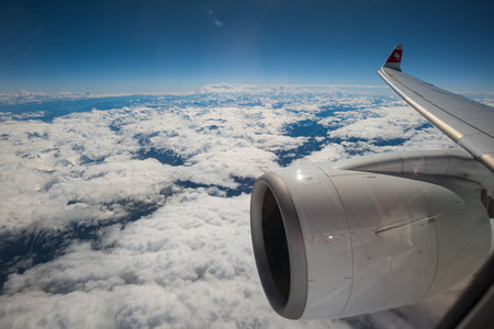 Swiss air commercial airplane flying over the clouds. Visible jet engine, wing and logo. Flying on...