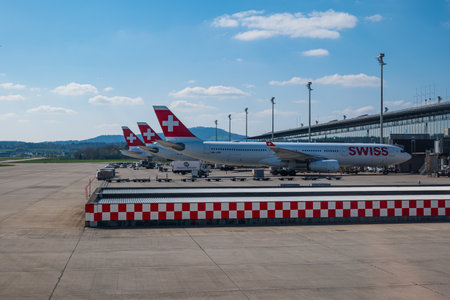 3 commercial airplanes of Swiss Air company, grounded on Zurich airport on 04/09/2023. No people, parked near terminal tubes.のeditorial素材