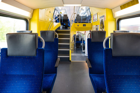 Empty seats on a passenger train in Europe. Wide-angle view, day time, no people.