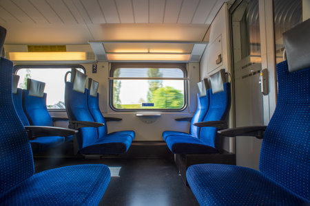 Passenger train with empty seats. Wide-angle long exposure, blurry green background out the window of an empty train in Switzerland, Europe, no people.の写真素材