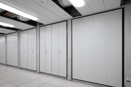 Long interior empty corridor hallway illuminated by neon lights with locker doors across both side, no people.の写真素材