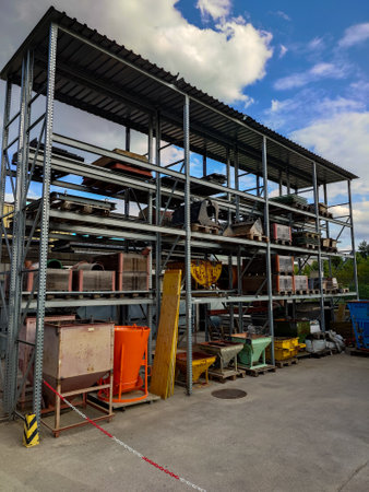 Contruction site stacked storage shelves with pallets, cement mixers and raw materials. Exterior shot, sunny blue sky, no people.の写真素材
