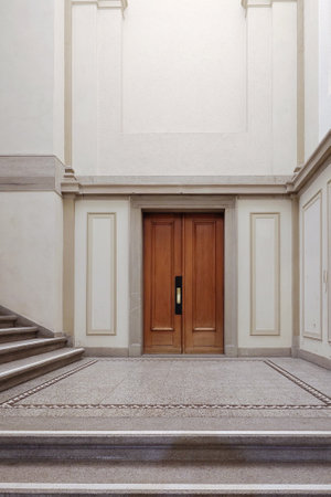 Large old fashioned hardwood, closed wooden door inside large public building corridor or hallway. no people.の写真素材