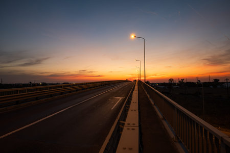 Urban concrete bridge silhouette at dusk. Glowing street light, wide angle, no people