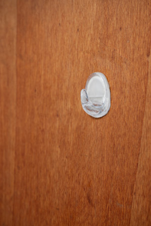 White plastic stick on hanger hook on a wooden door, close up shot, no people.の写真素材