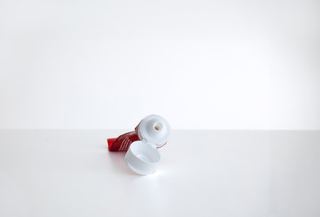 Rolled and squeezed out empty plastic toothpaste tube, isolated on white, close up shot.の写真素材