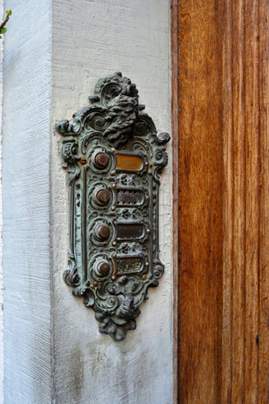 Old vintage, sculpted and decorated boor buzzer or intercom on an outside wall next to entry door. Close up shot, no people.の写真素材