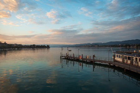 03-09-2024 Zurich, Switzerland. Pier and tourist boats on lake Zurich at sunrise. Beautiful dawn sky and water reflections, early summer morning.のeditorial素材