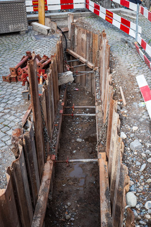 06-09-2024 Zurich, Switzerland. Constructions site ditch or pit on a cobblestone road near Grossmunster church. Top view, daytime, no people.のeditorial素材