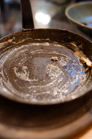 Cast iron saucer pan or skillet stained with leftover sauce. Top view, close up shot, shallow depth of field, no people.の写真素材