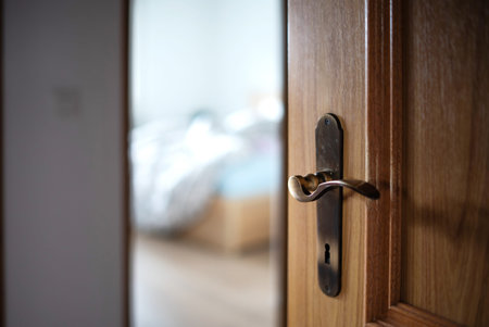 Open, wooden apartment door and vintage metal lock and handle. Close up shot, shallow depth of...