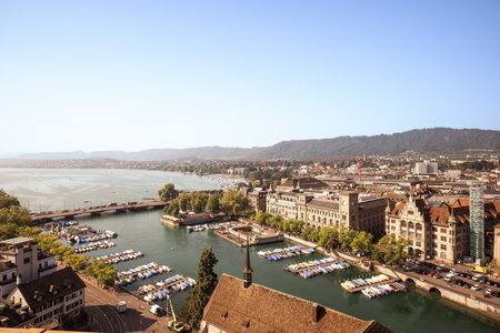 28-08-2024 Zurich, Switzerland. Aerial view of the Limmat river swelling into lake Zurich. Summer day, wide angle view of the Burkiplatz marina, Quai bridge and docked small boats on the river docks.の写真素材