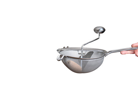 Stainless steel sieve with crank. Held by hand by Caucasian male hand. Close up studio shot,...