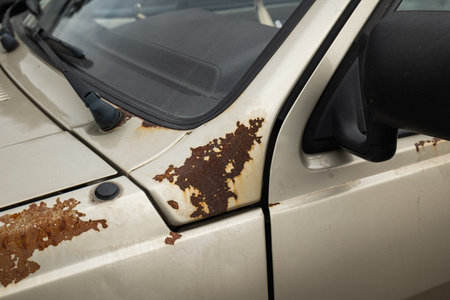 Old, rusted car body panels. Close up shot of rust patches on an old car, no people.