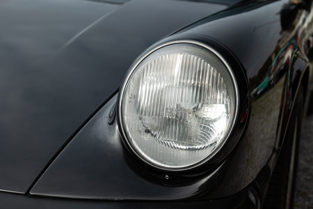 Vintage car headlight or headlamp unit. Close up shot, shallow depth of field, no people.