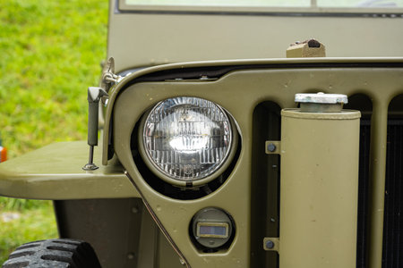 6-10-2024 Zurich, Switzerland. WW2 era green, army Jeep Willys at a car show. Front, close up detail...