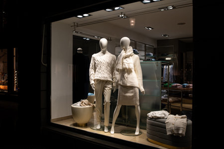 Female and male mannequins in store glass window display dressed casual autumn â€” winter...