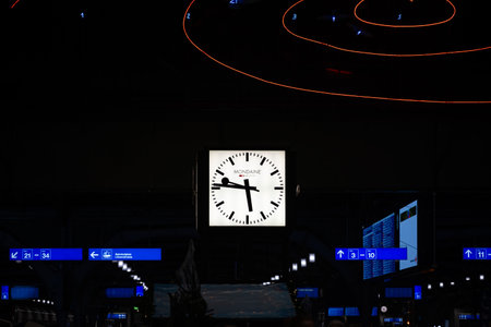18-11-2024, Zurich, Switzerland. Large, famous, square Mondaine clock at Zurich main station at night. Interior shot, looking up view, no people.のeditorial素材