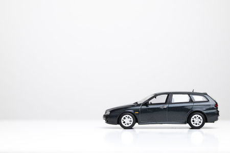 Small metal toy model car isolated on white. Close up shot, side profile, dark gray station wagon, no people.の写真素材