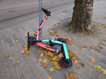 Two electric city scooters toppled over on a city street in Europe, top view, no people.の写真素材