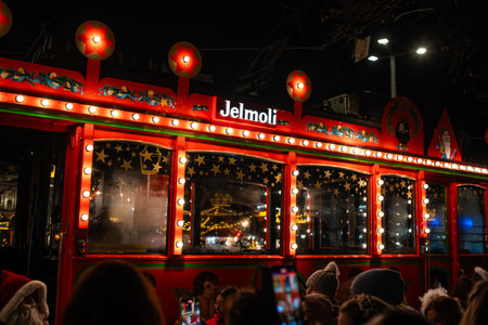 3-12-2024 Zurich, Switzerland. People gathering around to board the famous Christmas theme decorated Jelmoli vintage tram in the late evening.のeditorial素材