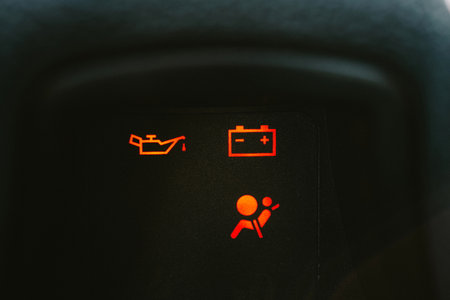 Car dashboard with illuminating check engine, check oil and check seat belt light on. Close up shot, no people.の写真素材