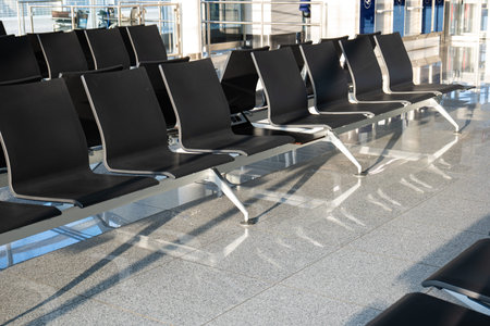 Empty rows of seats and benches inside international airport terminal. Departure waiting room near...