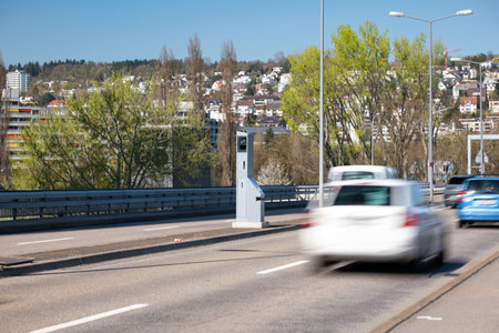 Blurry cares driving by a gray, mobile, car traffic speed trap camera between two car lane. Close up, telephoto shot.の写真素材