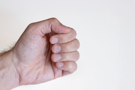 Caucasian male's hand and closed up fingers and fingertips with trimmed nails. Close up studio shot, isolated on whiteの写真素材