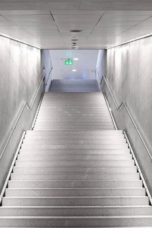 Underground, concrete, gray staircase with metal handrails. Looking up, wide angle shot, no peopleの写真素材