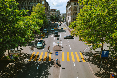 Pedestrian crossing or yellow zebra across 4 lane traffic road in a city in Europe. Overpass or above point of view, looking down, summer daytime, wide angle viewの写真素材