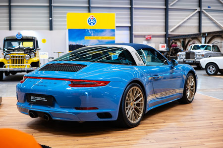 Blue Porsche 911 targa 2S sports car on the showroom floor of a car exhibition. Rear view, no peopleの写真素材