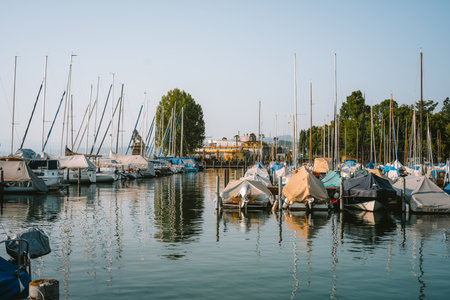Docked sail boats in a shipyard or lake harbor in a town in Europe. Sunny summer day, wide angle, no people.の写真素材
