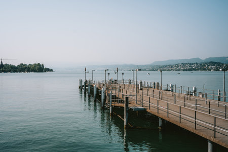 Empty lake pier stretching out to sea. Sunny summer day, bright natural light, no peopleの写真素材