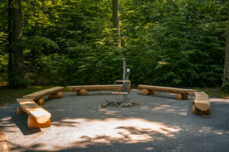 Newly build picnic benches in a public forest campsite in Europe. Wide angle view, sunny summer day, green vegetation, no peopleの写真素材