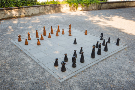Large, public park chess board  with giant wooden pieces. Top down, wide angle view, sunny summer day, no peopleの写真素材