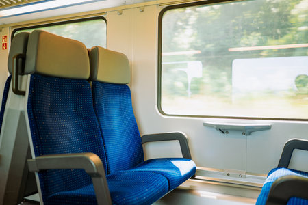 Empty window seats on a passenger train in Europe. Blurred, bright exterior view, wide angle, no peopleの写真素材