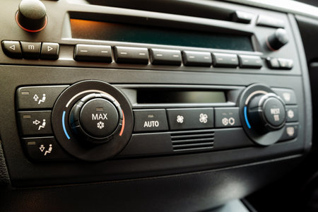 Car dashboard AC control panel with physical button and small LCD. Close up, detail show, snowflake pictogram to denote air conditioning, no peopleの写真素材