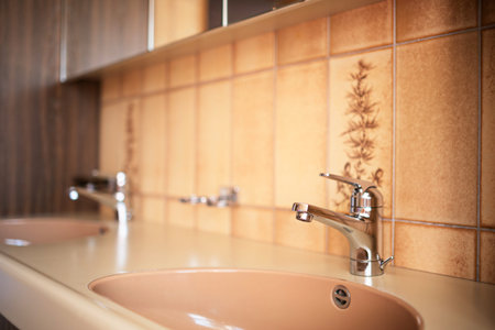 Shiny, chrome water tap inside apartment bathroom. Close up shot, shallow depth of field, no peopleの写真素材