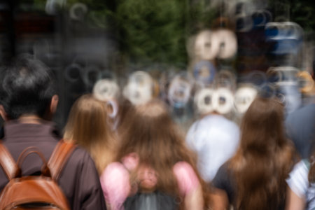 Blurry, defocused, unrecognizable people or pedestrians on a busy urban sidewalk. Sunny summer day, doughnut shaped bokehの写真素材