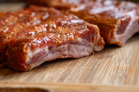 Raw, seasoned and marinate pork ribs or spare ribs on a wooden kitchen board. Close up shot, no peopleの写真素材