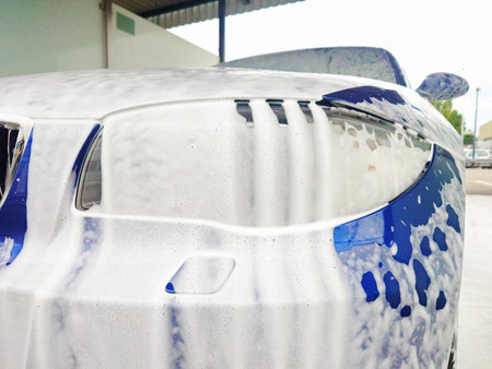Foam covered blue car at a self service car wash. Close up detail shot, wide angle view, no peopleの写真素材