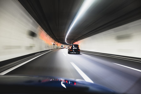 Blurry cars driving through a tunnel in Europe. Long exposure, artificial illumination, through the windshield point of view, no peopleの写真素材