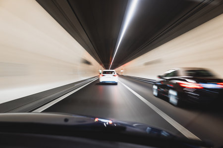 Blurry cars driving through a tunnel in Europe. Long exposure, artificial illumination, through the...