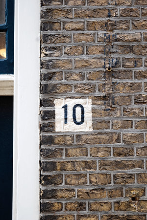 House number ten painted mark on brick wall home entrance. Close up shot, no peopleの写真素材