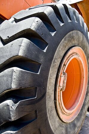 A huge tractor wheel with a black tire.の写真素材