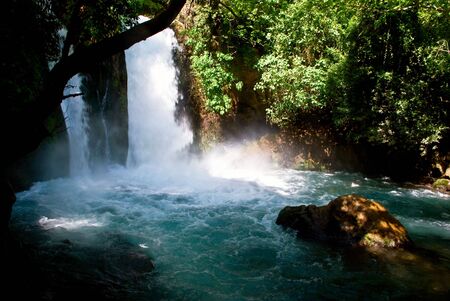 Small waterfalls dropping into the lake through forest treesの写真素材