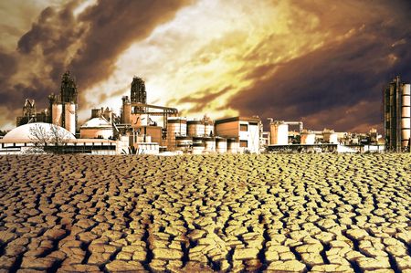 Killed nature. Cracked dried ground in front of an industrial plant.の写真素材