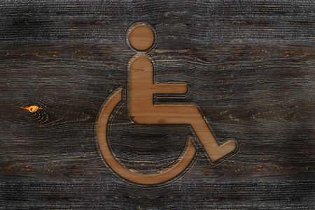 An illustration of a wooden carved wheelchair sign.の写真素材