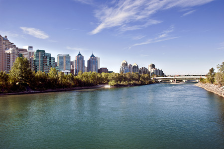 A pedestrian bridge accross  Bow River in Calgary with skyscrapers in the background.の写真素材